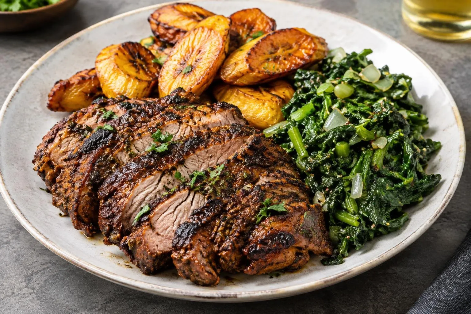 Caribbean Jerk Grilled Pork with Sweet Plantain and Callaloo Sauté plated and ready to serve